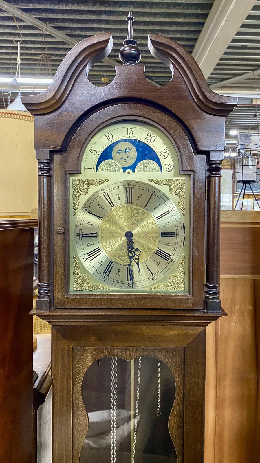 An old wooden standing clock which seems to have a day and night mechanism. It points at 29 minutes past 5.