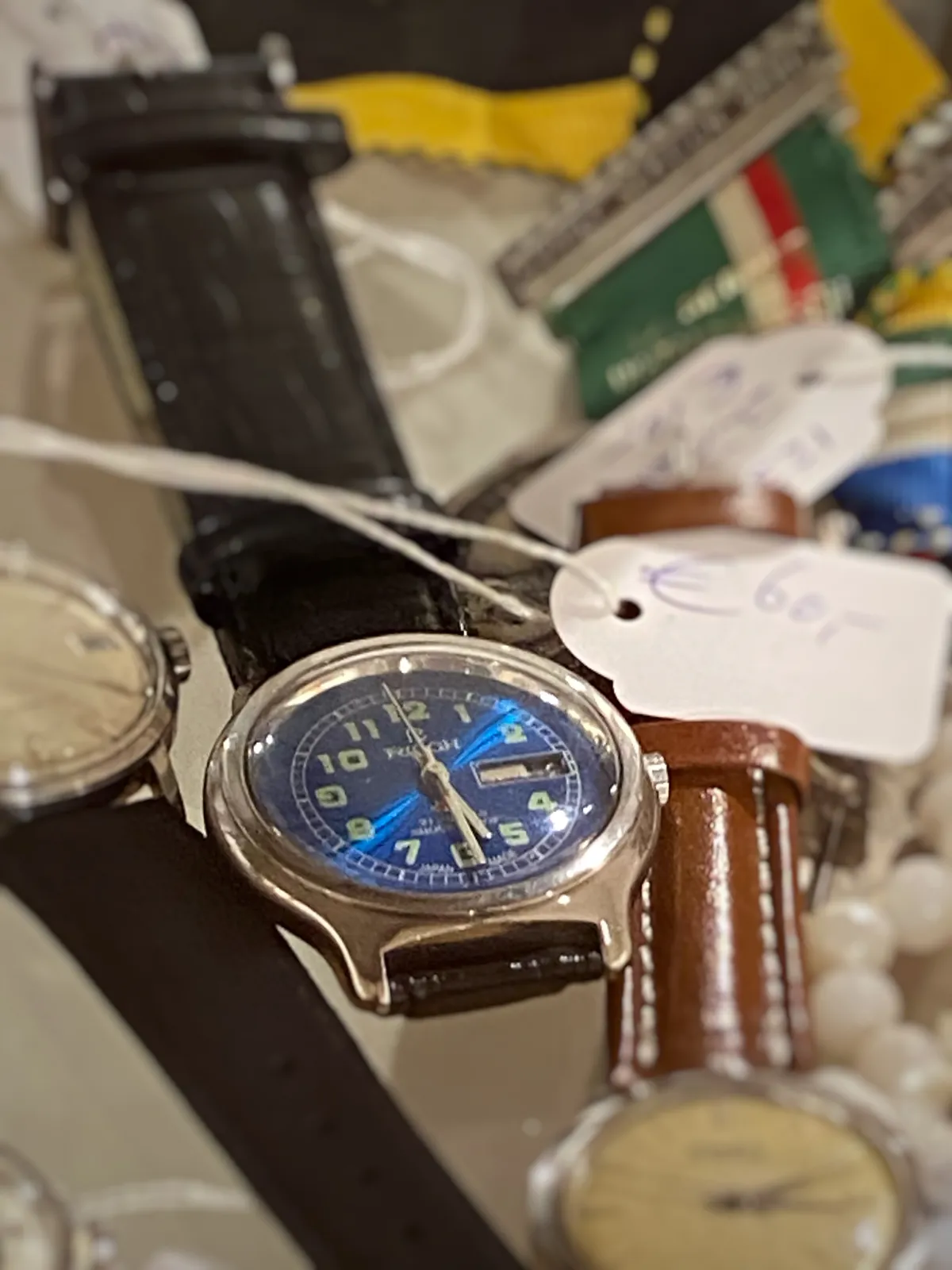 A few different wrist watches on display here. Just one of them is clearly in focus. It points at 29 minutes past 5.