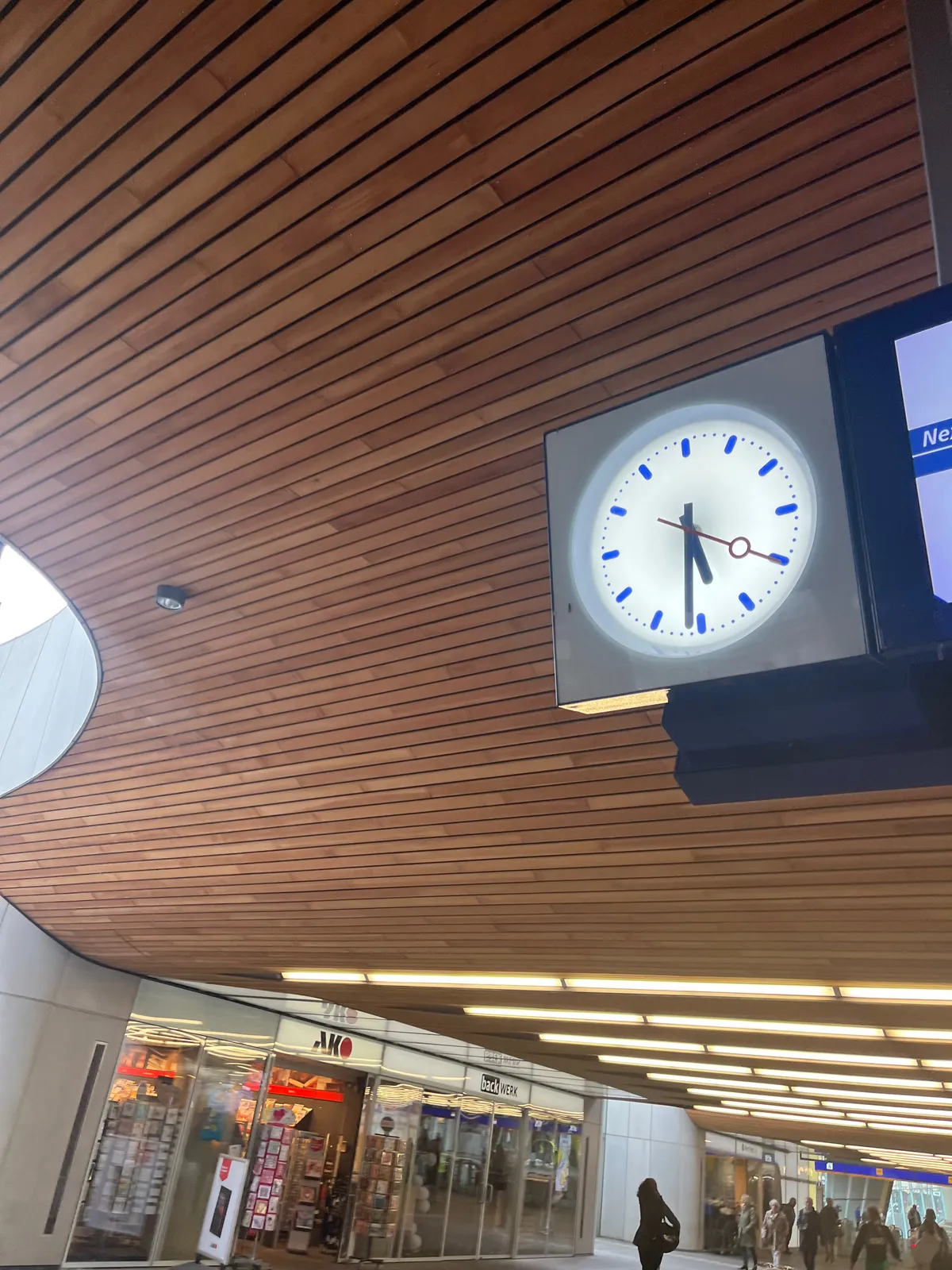 A clock in a train station points at 31 past 5.