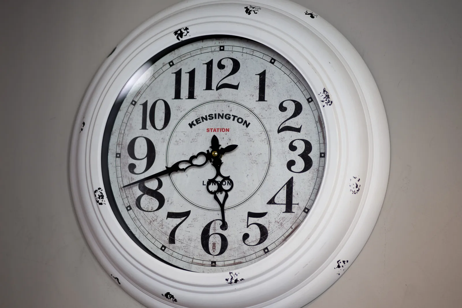 A black and white clock. It says Kensington Station. It points at 42 minutes past five.