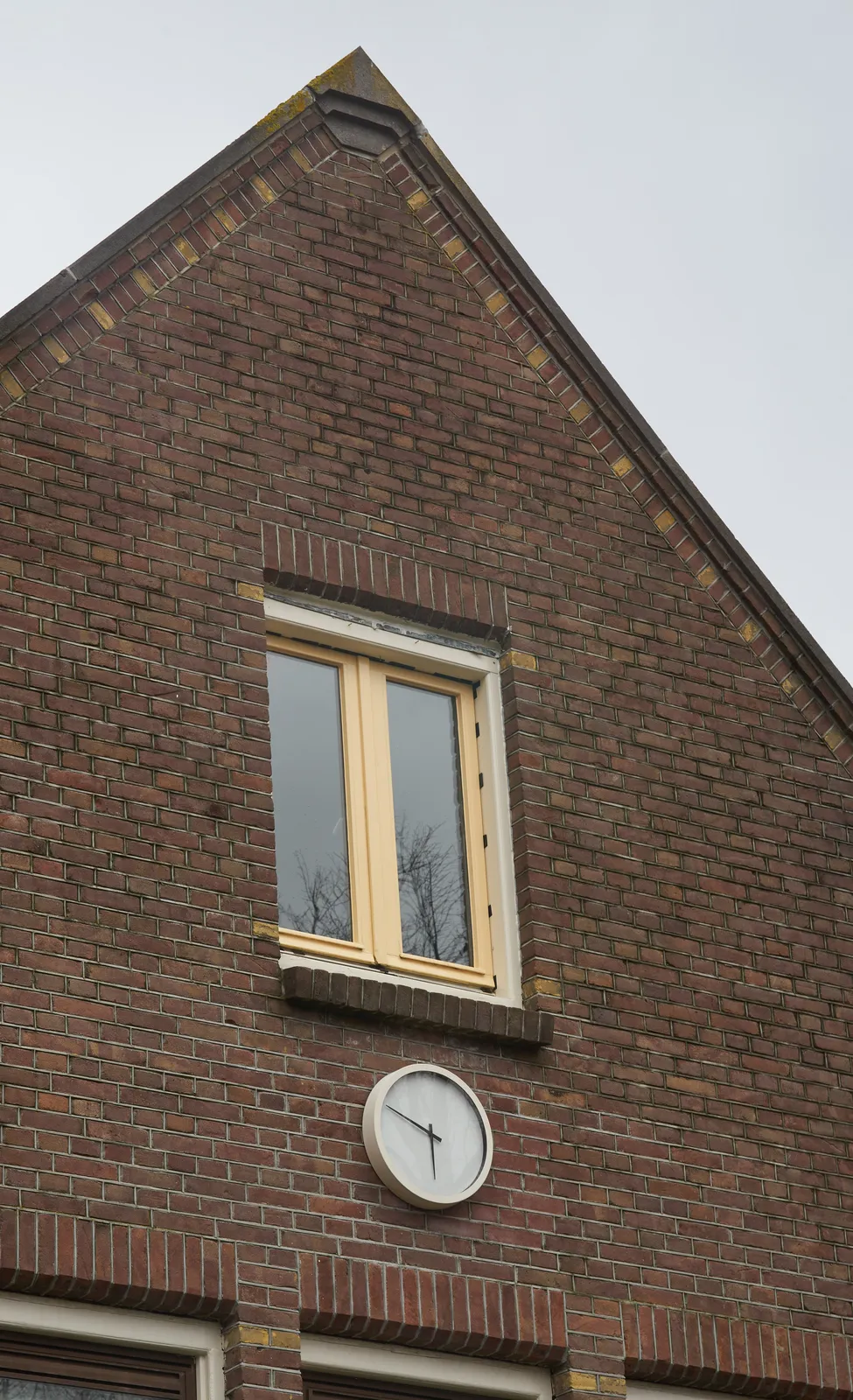 A surprisingly modern clock on a not so modern house points at 11 to 6.