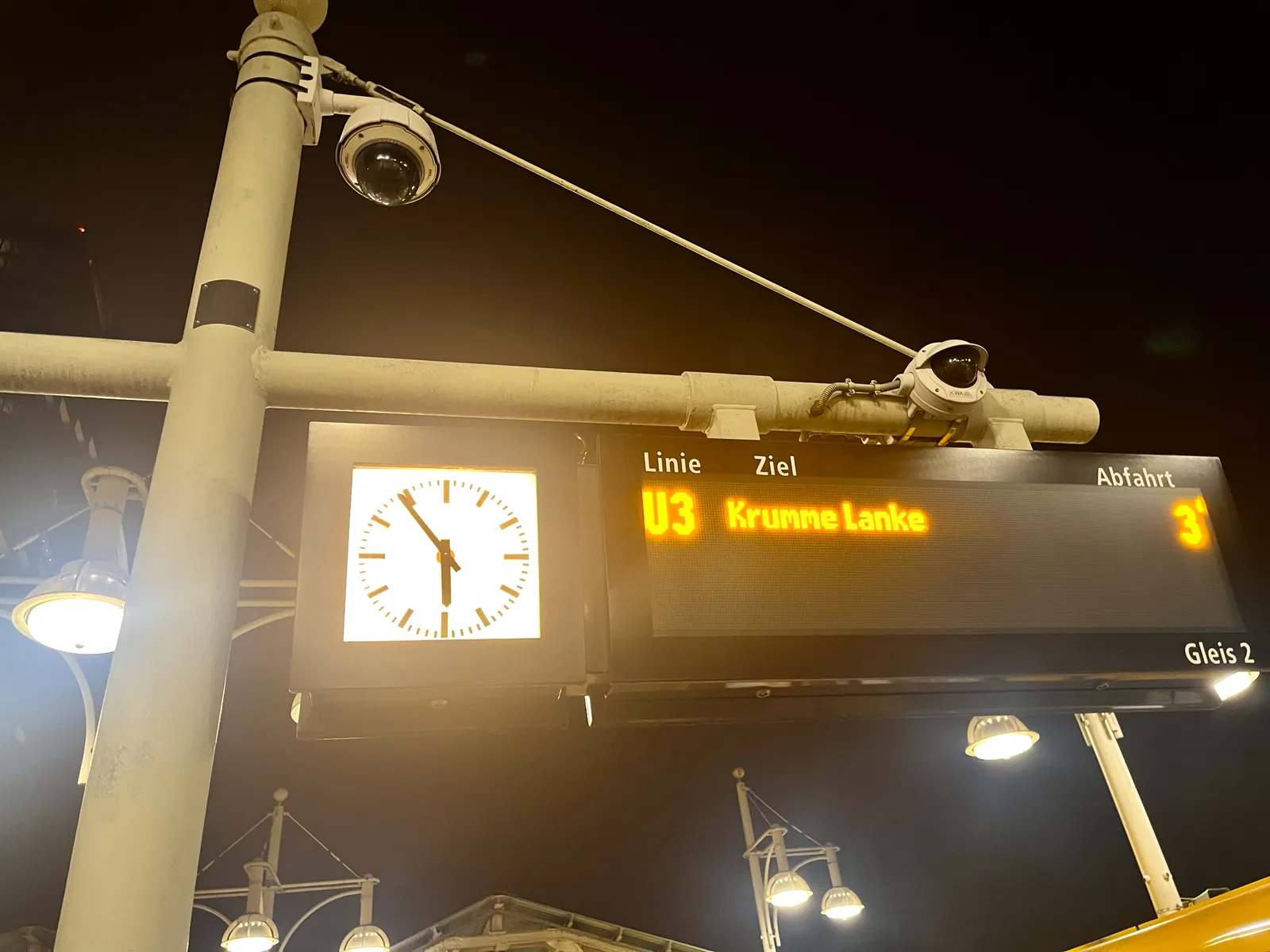 A digital display tells us that the metro to Krumme Lanke will leave in three minutes. A camera is watching us. And there’s a clock that points at 6 minutes to 6.