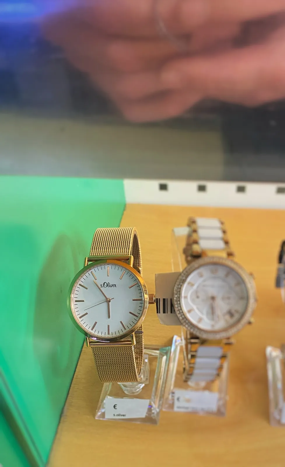 Two watches. The one that’s in focus has the name S. Oliver. It points at 6 minutes to 6.