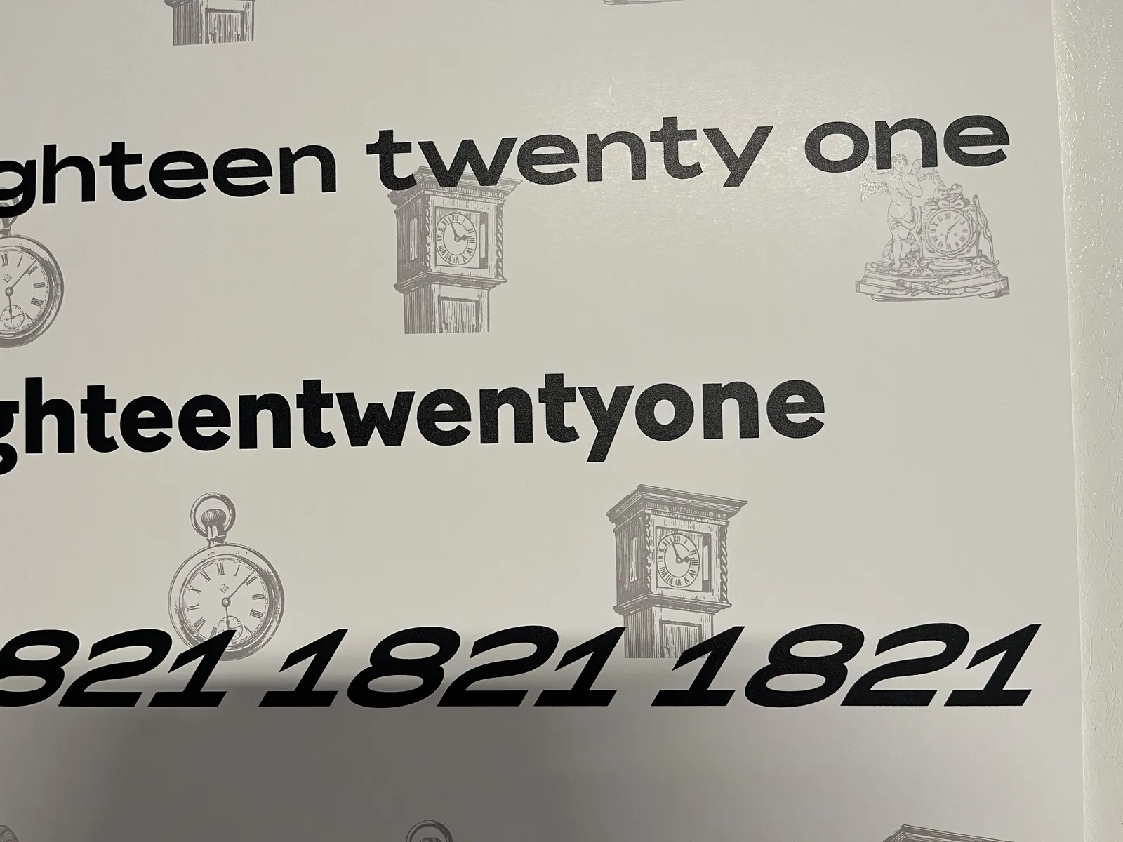 A print with eighteen twenty one printed on it in several different ways. This could be the time. But there’s also a pattern of clip art clocks printed on the background. One of these clocks points at 3 minutes to three, another one at seven minutes past six, and there’s one that points at nine minutes past six.  