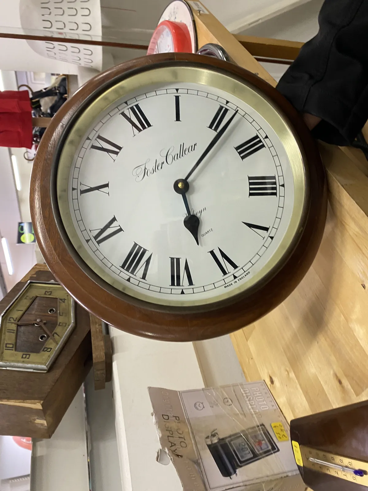 A wooden clock. It’s placed on its side. but since the image is rotated it looks okay-ish. It points at 11 past 6.