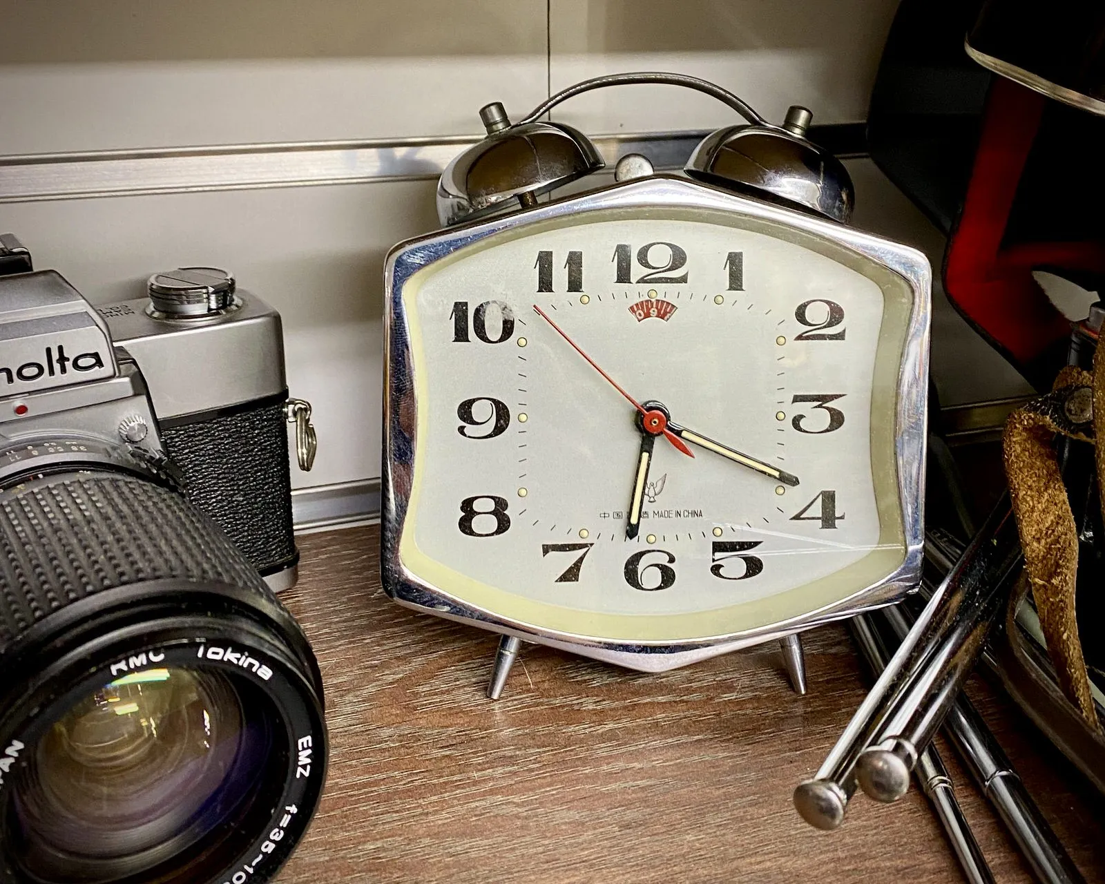 On this clock, next to it is an old Minolta camera, it is 19 past 6.