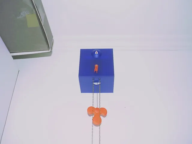 The orange hands on this blue cube clock point at six thirty.