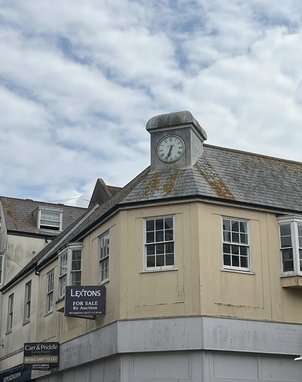A building on a corner, for sale by auction by Lexton. There’s a clock on this building, which points at 33 minutes past six.