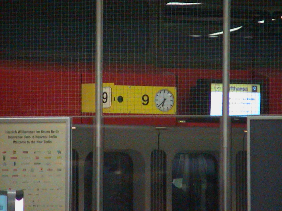 A clock on an airport says it is thirty eight past six.