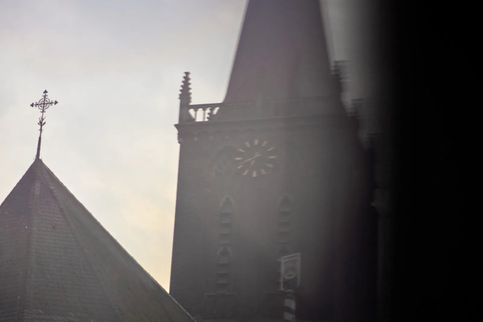 A bit blurry shot of a church tower with a clock. On the clock it’s 41 past six.