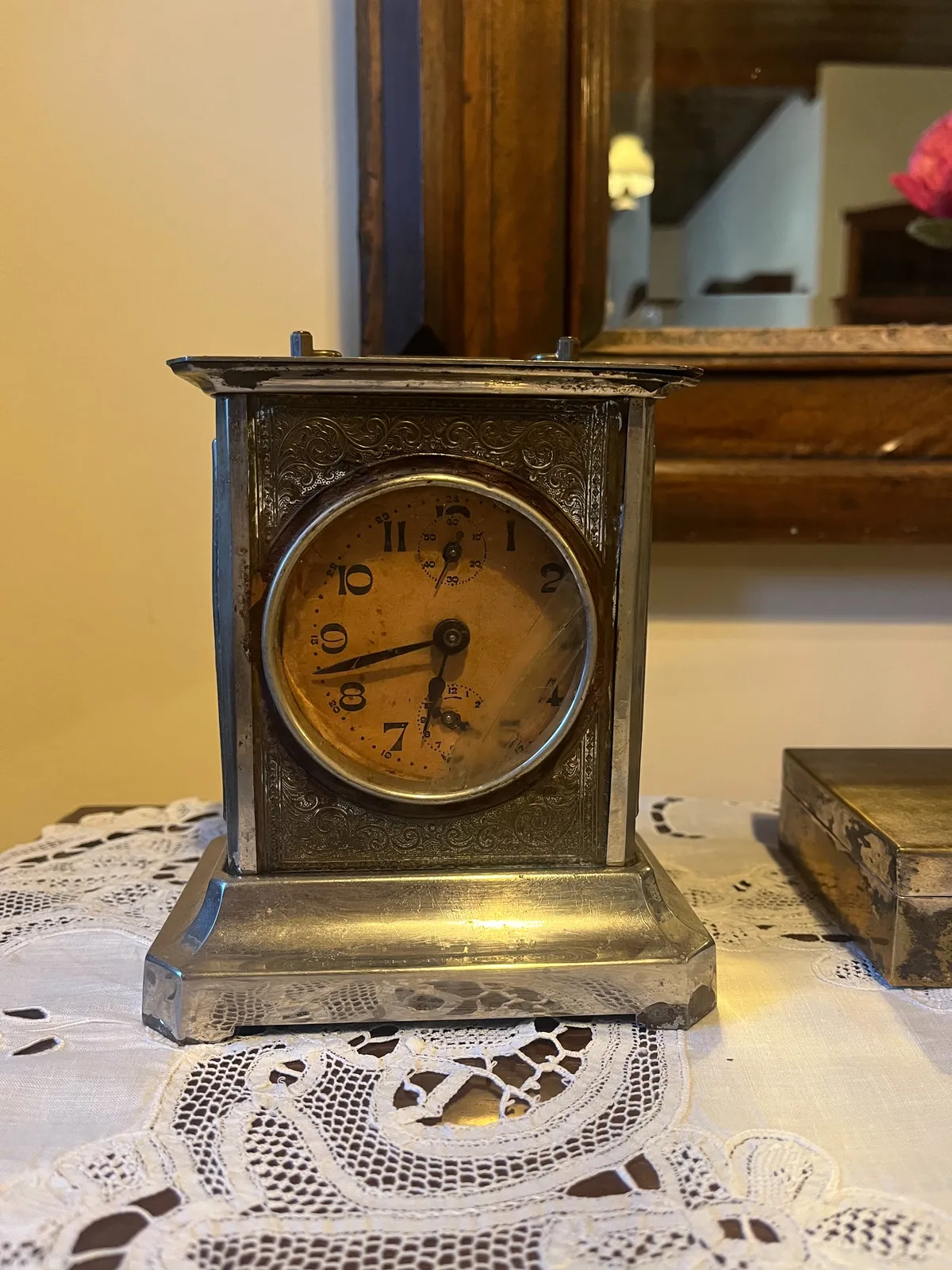 A silver table clock, with striking numbers on its face. In typefaces with contrast, the vertical strokes of letters are usually wider than the horizontal ones. This typeface doesn’s follow this convention. The clock points at 18 minutes to seven. 