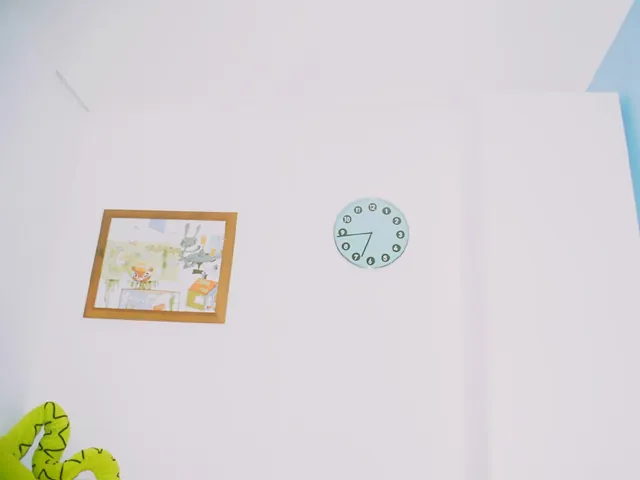 This wall clock, next to a drawing, points at forty four past six.