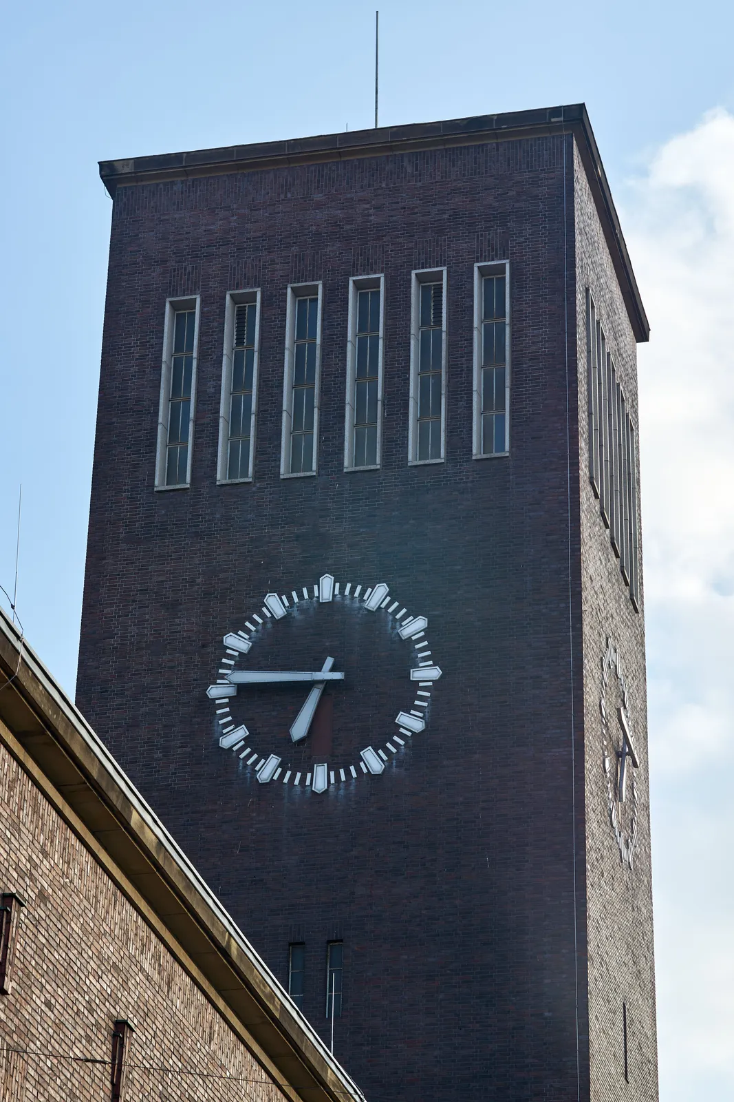 The clock on the tower of the Düsseldorf train station points at 14 minutes to 7.