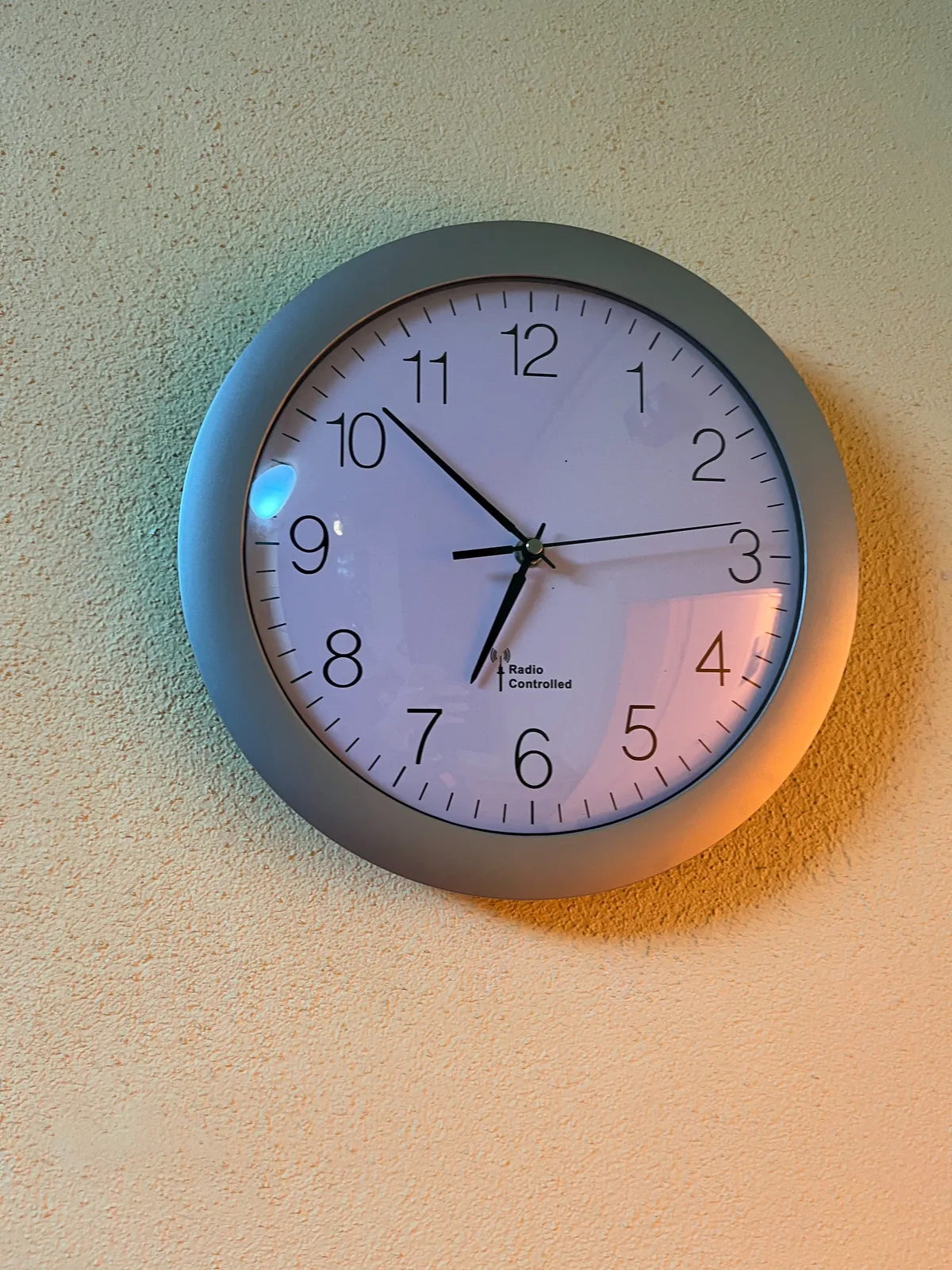 A clock on the wall points at 8 minutes to 7.