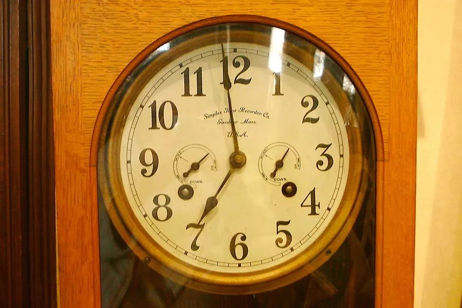 The hands of this old clock point at one minute to seven.