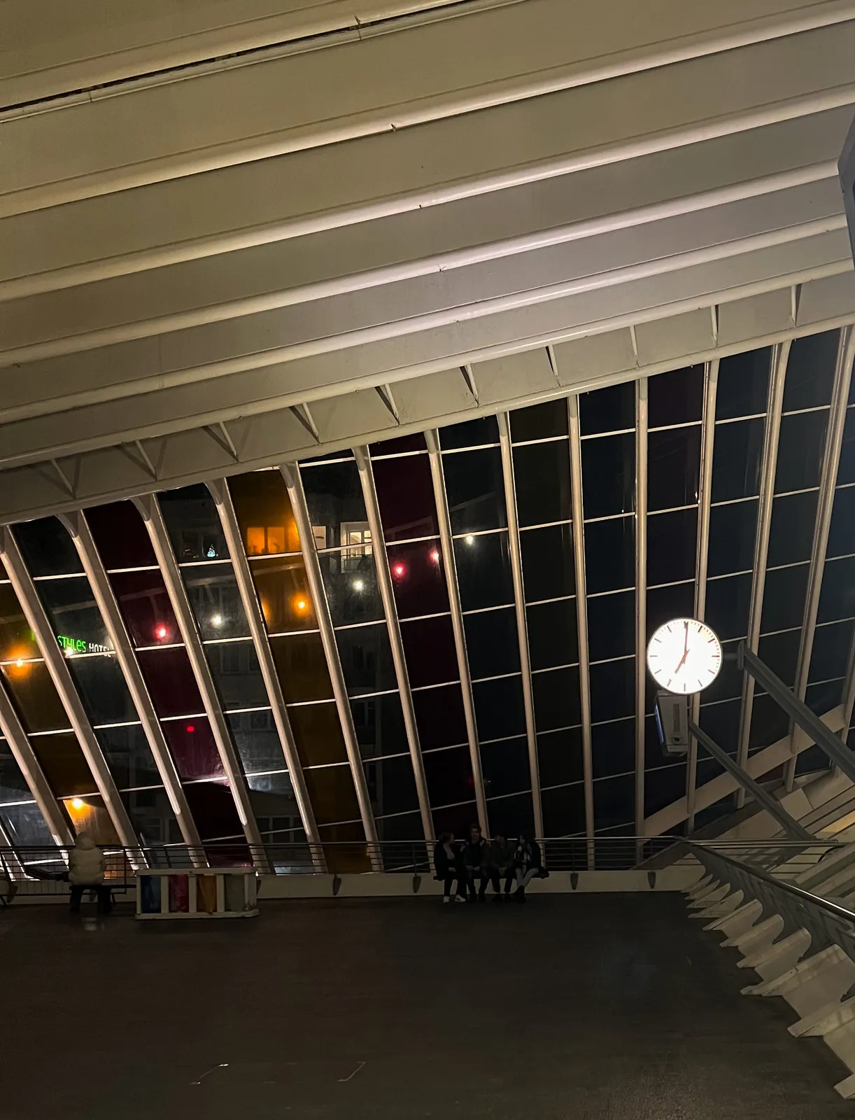 The composition is made up of the rhythmic pillars of Liège Guillemins station. There’s also a clock. It points at one past 7.