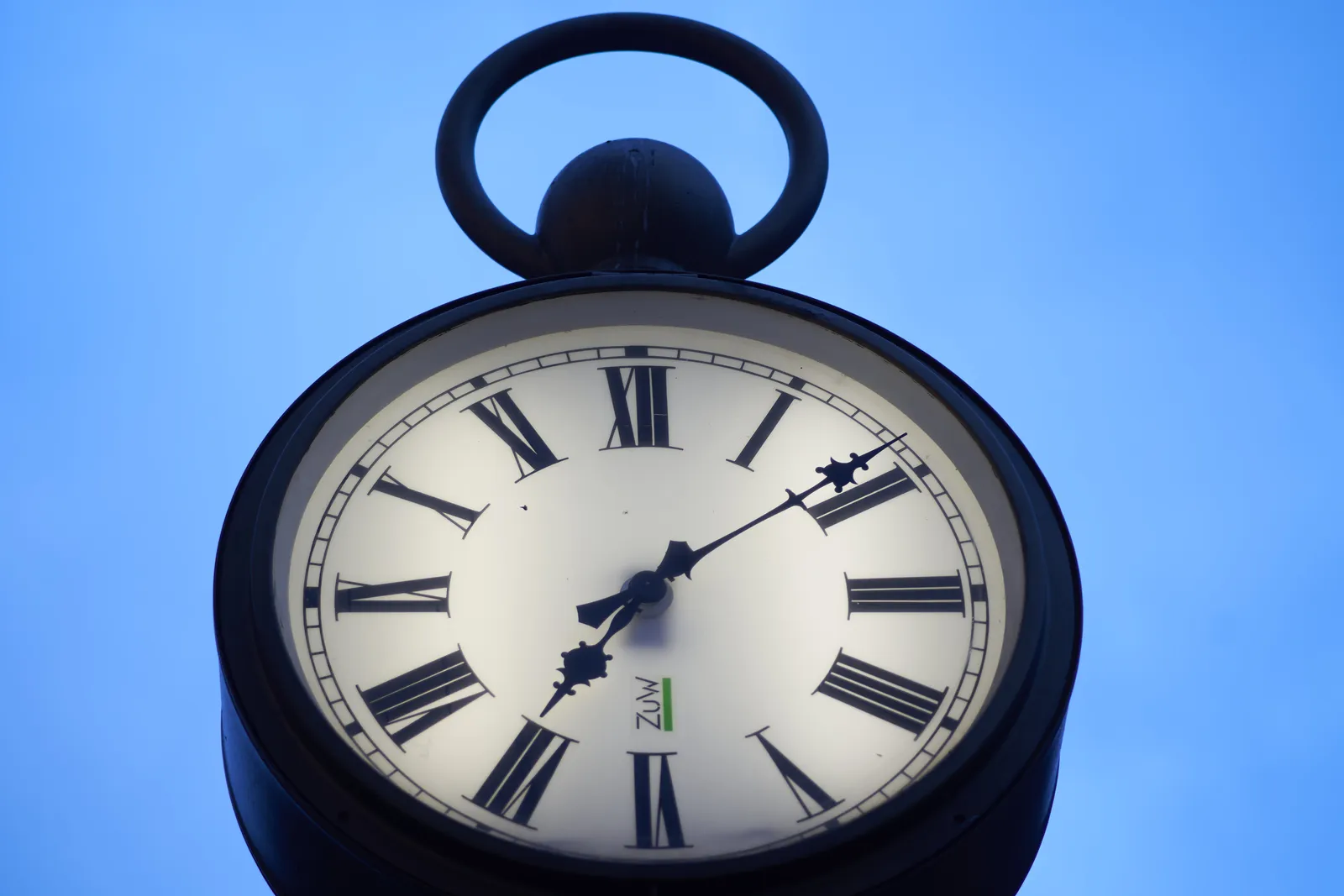 A large clock in the shape of an old watch. It points at 8 minutes past 7.
