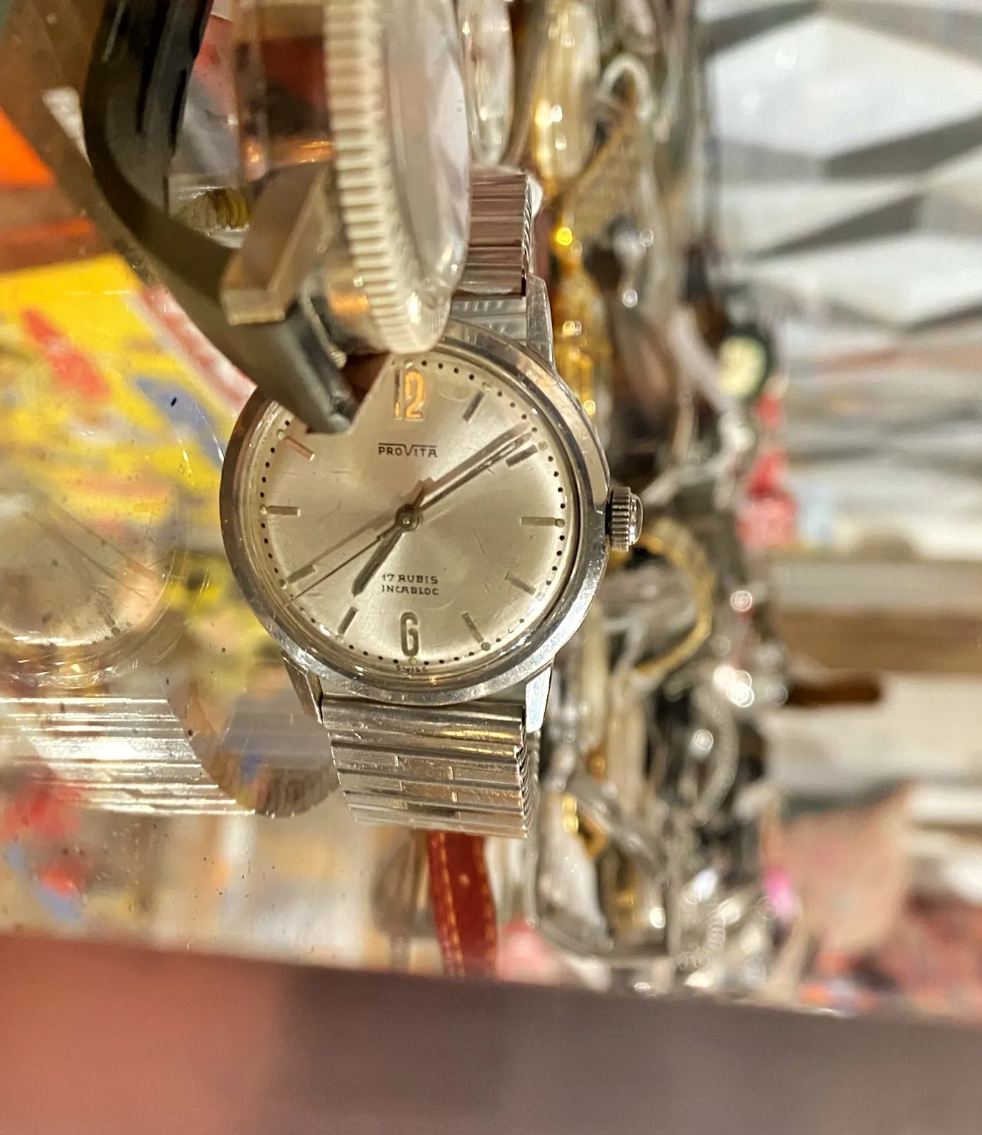 A disorienting image. It looks like a lot of watches are glued to the wall. In reality the image is rotated 90 degrees. This makes it look like the one watch that is in focus is upright. Makes it much easier to see that it points at 9 minutes past 7.