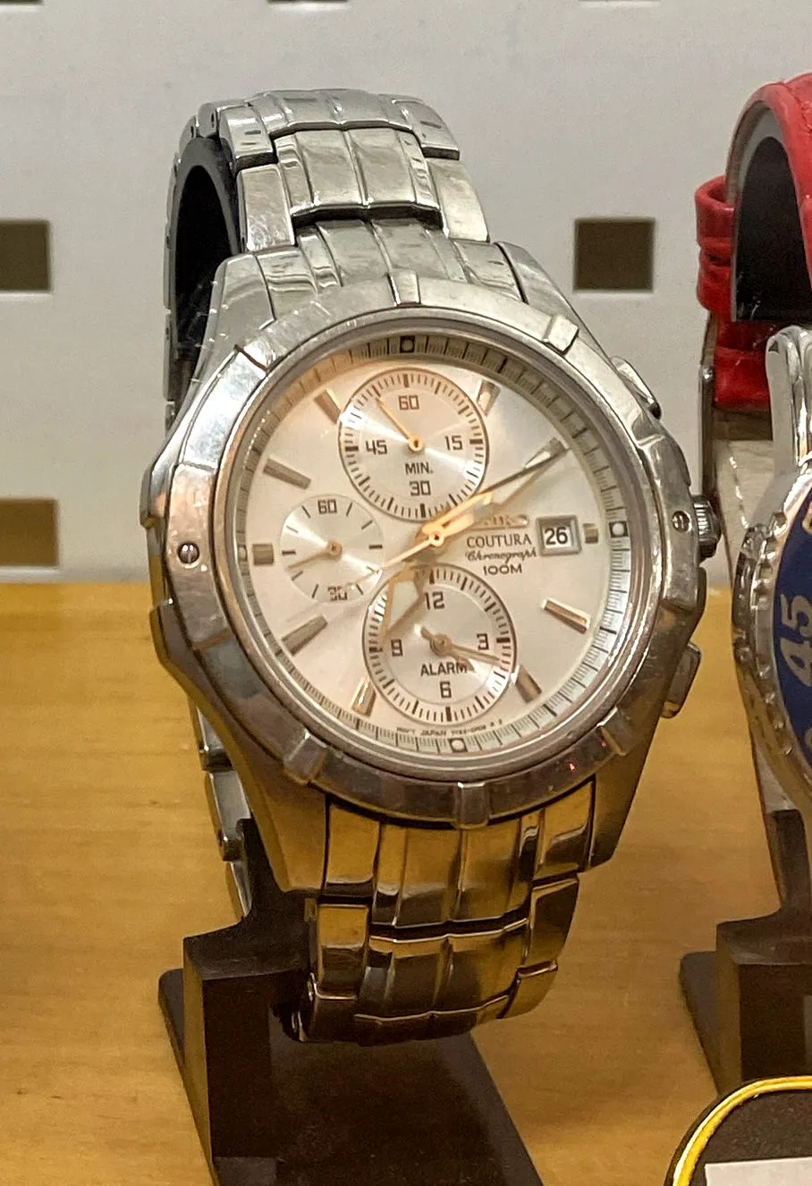 A large, solid metal wrist watch. It points at 10 past 7.