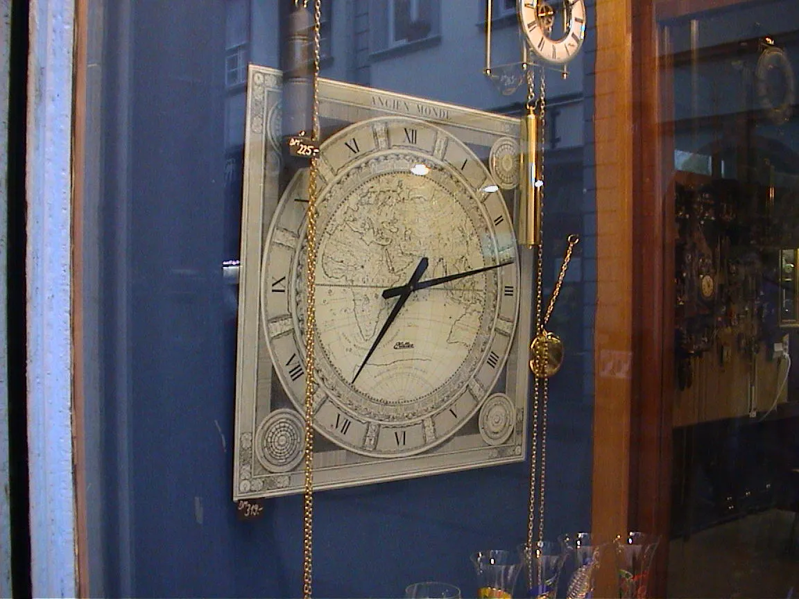 This clock with a map of the ancien monde on it, points at eleven past seven.