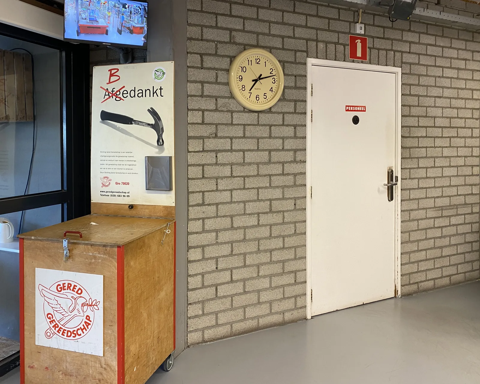 On the left there’s a cupboard where you can leave tools that you don’t need anymore. On the right there’s a gray wall. On the wall there’s a clock that points at 12 past 7.