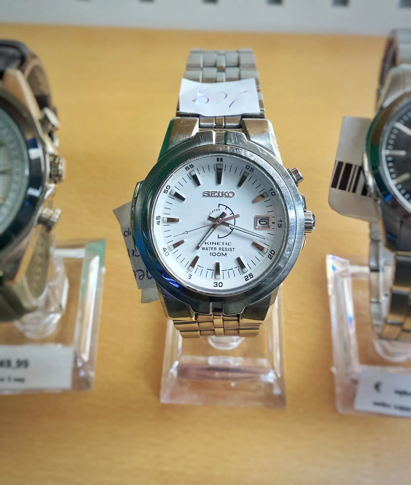 A Seiko Kinetic watch. It points at 18 past 7.