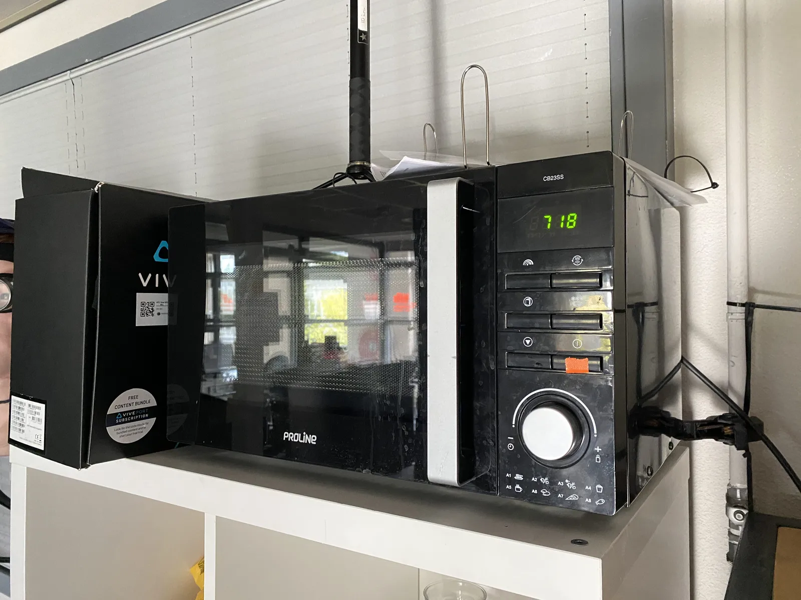 According to the clock on this black microwave it is 18 past 7.