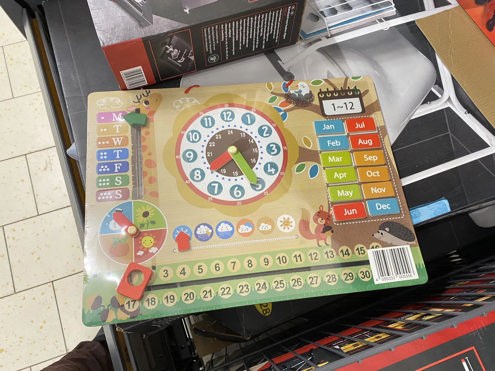 A kids board game with a clock. It points at 25 minutes past 7.