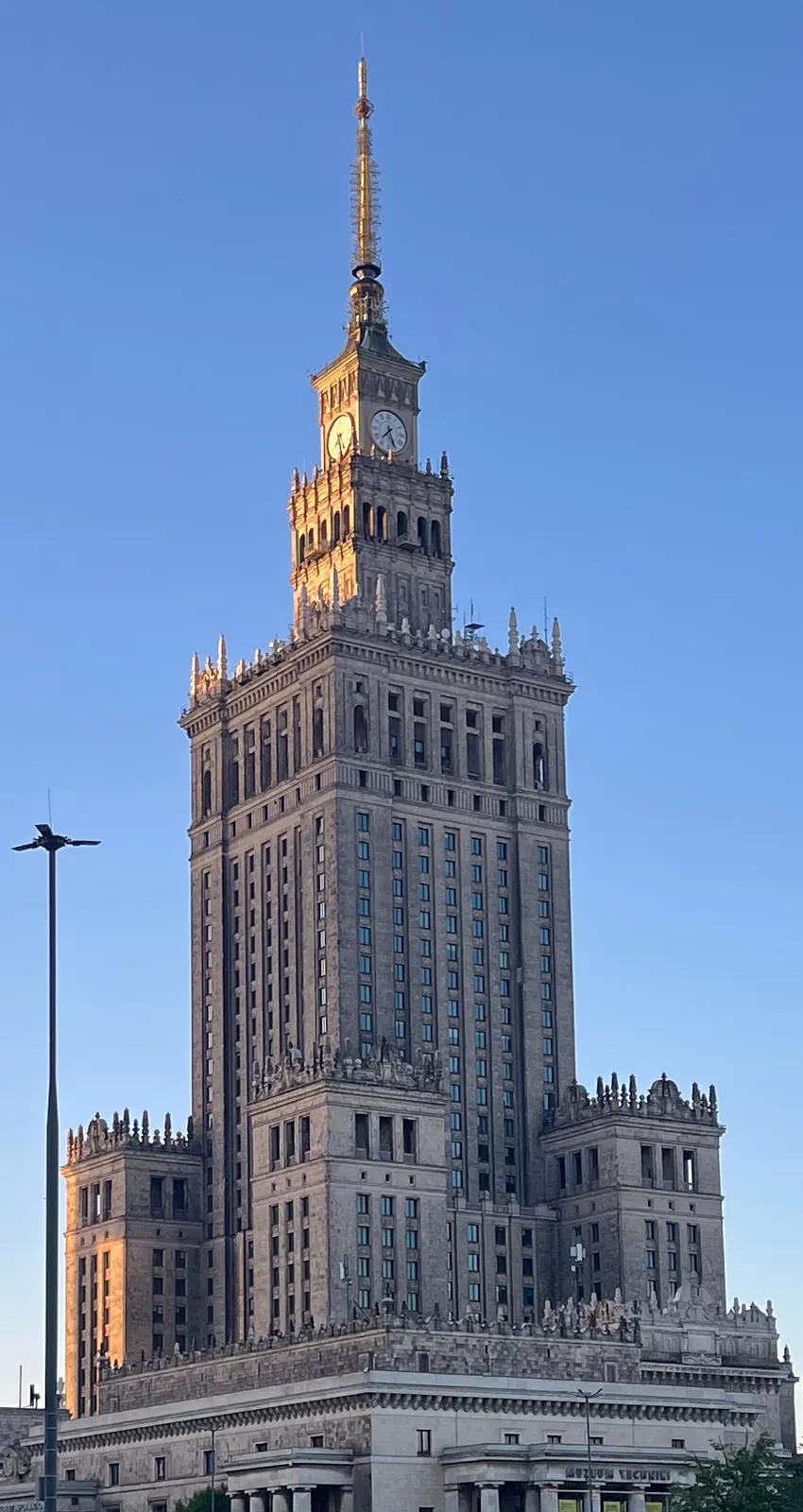 The enormous Palace of Culture and Science in Warsaw. There’s  a clock on top of it and it points at 26 minutes past 7.