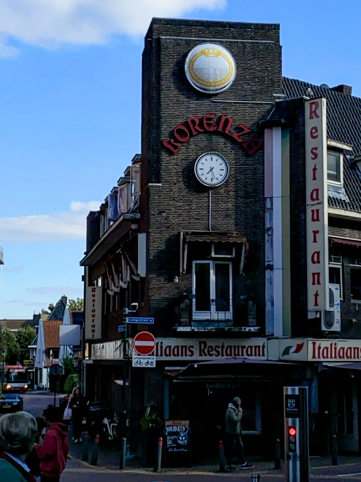 An intriguing, very Dutch, brick facade of an italian restaurant, called Lorenza. There’s a clock on this facade that points at 27 minutes past 7.
