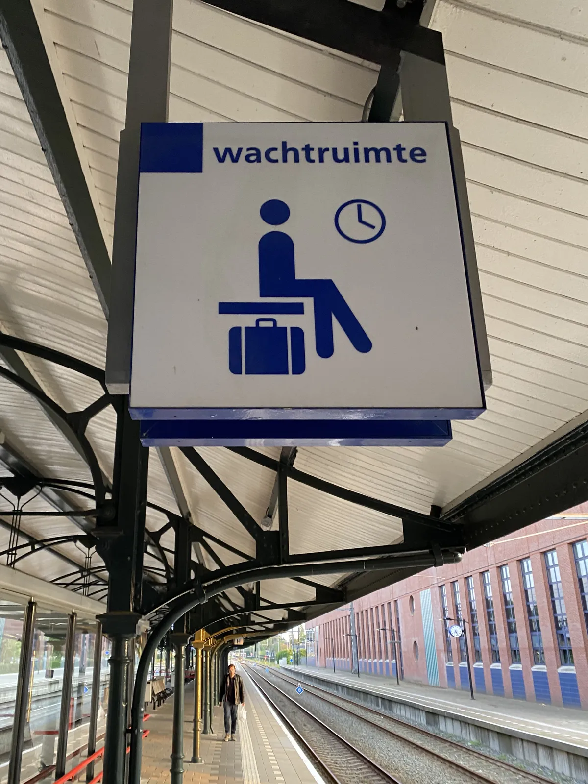 There are two clocks on this image. There’s a sign that indicates that there’s a waiting room. Part of that sign is a clock that points at 4 o’clock, which it is not at this moment. There’s also a clock in the distance, which points at 27 past 7.