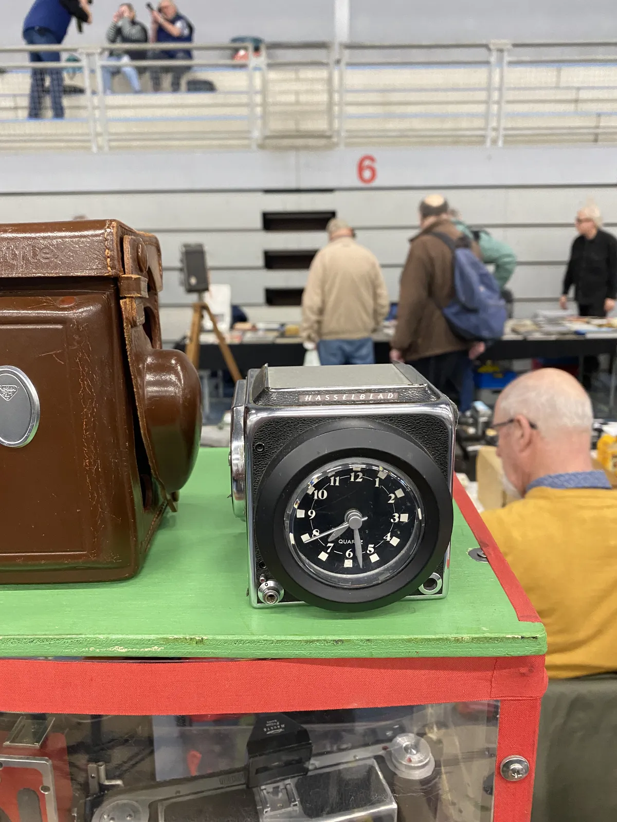 A clock built into a Hasselblad photo camera. It points at 28 minutes past 7.
