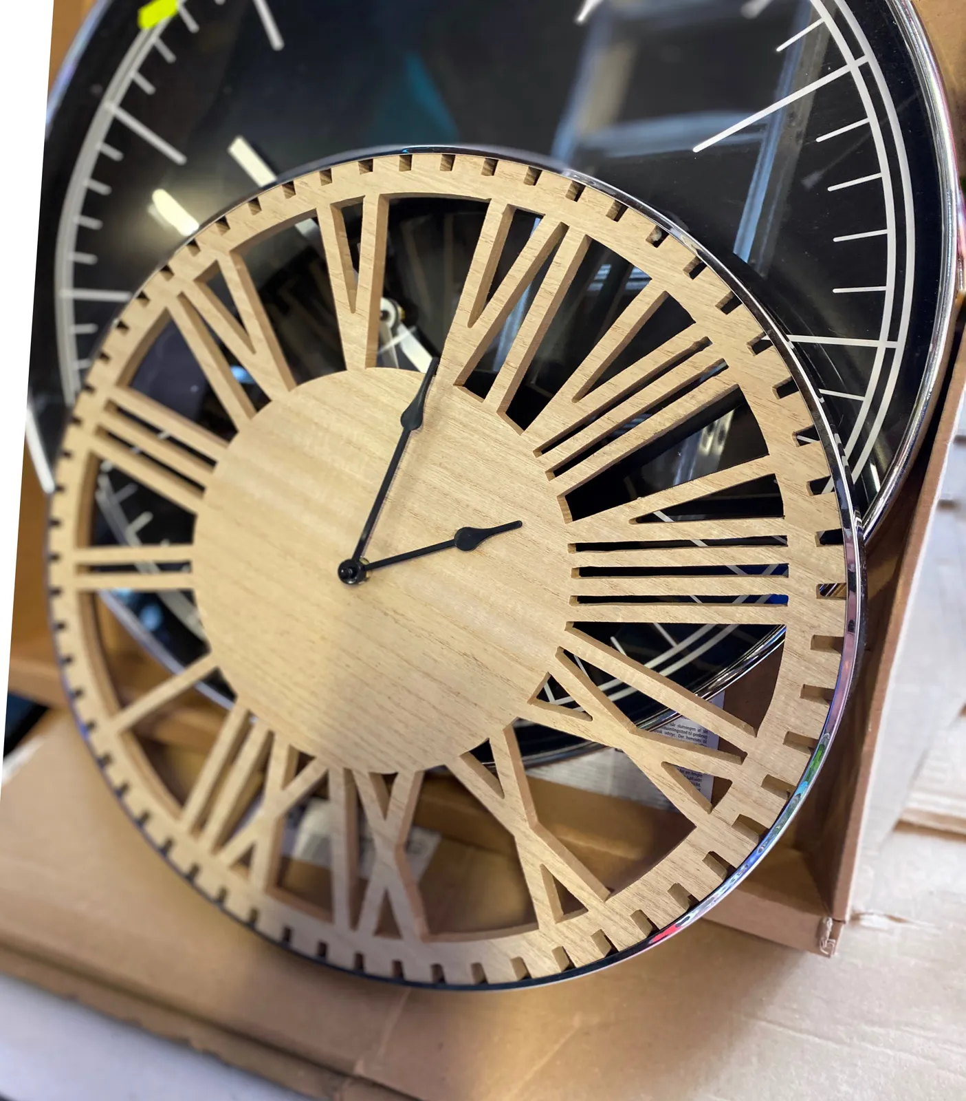 A clock with the space between the roman numerals cut out. It’s placed upside down so it’s quite hard to see that it is 29 minutes past 7.