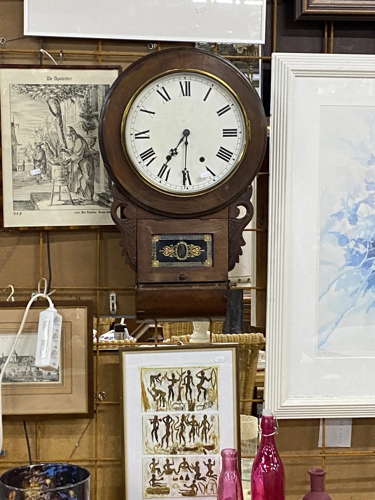 Prints and paintings for sale, and an old wooden clock that points at half past 7.