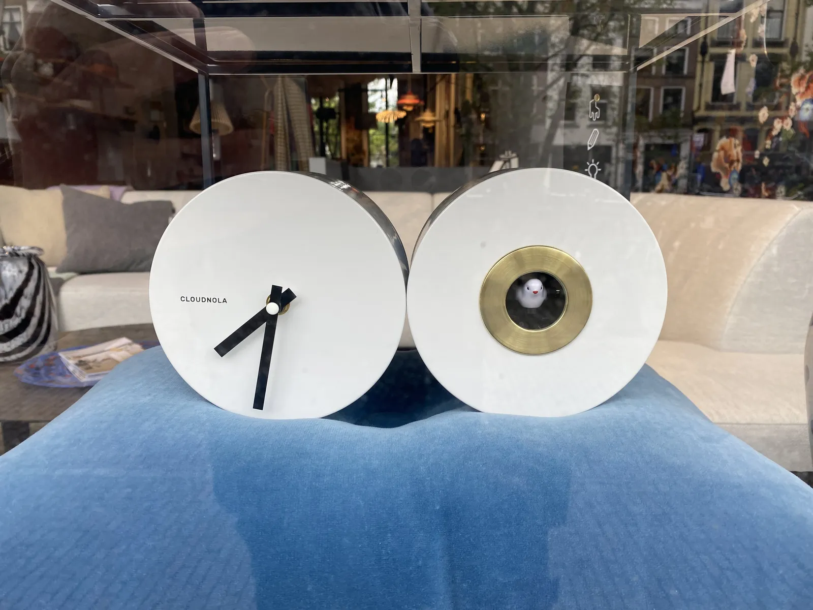 A very modern take on a cuckoo’s clock. On the right there’s a white circle with a white bird in it. On the left there’s a circle of the same size with a clock that points at 32 past 7.