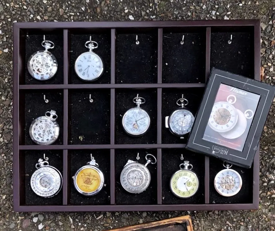 There are quite a few watches in a wooden frame. On some of them the time can be seen. Most of them point at the wrong time, but on one of them it is 32 past 7, which is correct.