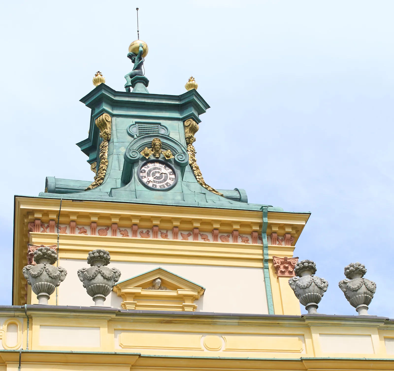 A clock with just one hand on an old, palace-like building. It points at approximately 20 minutes to 8.