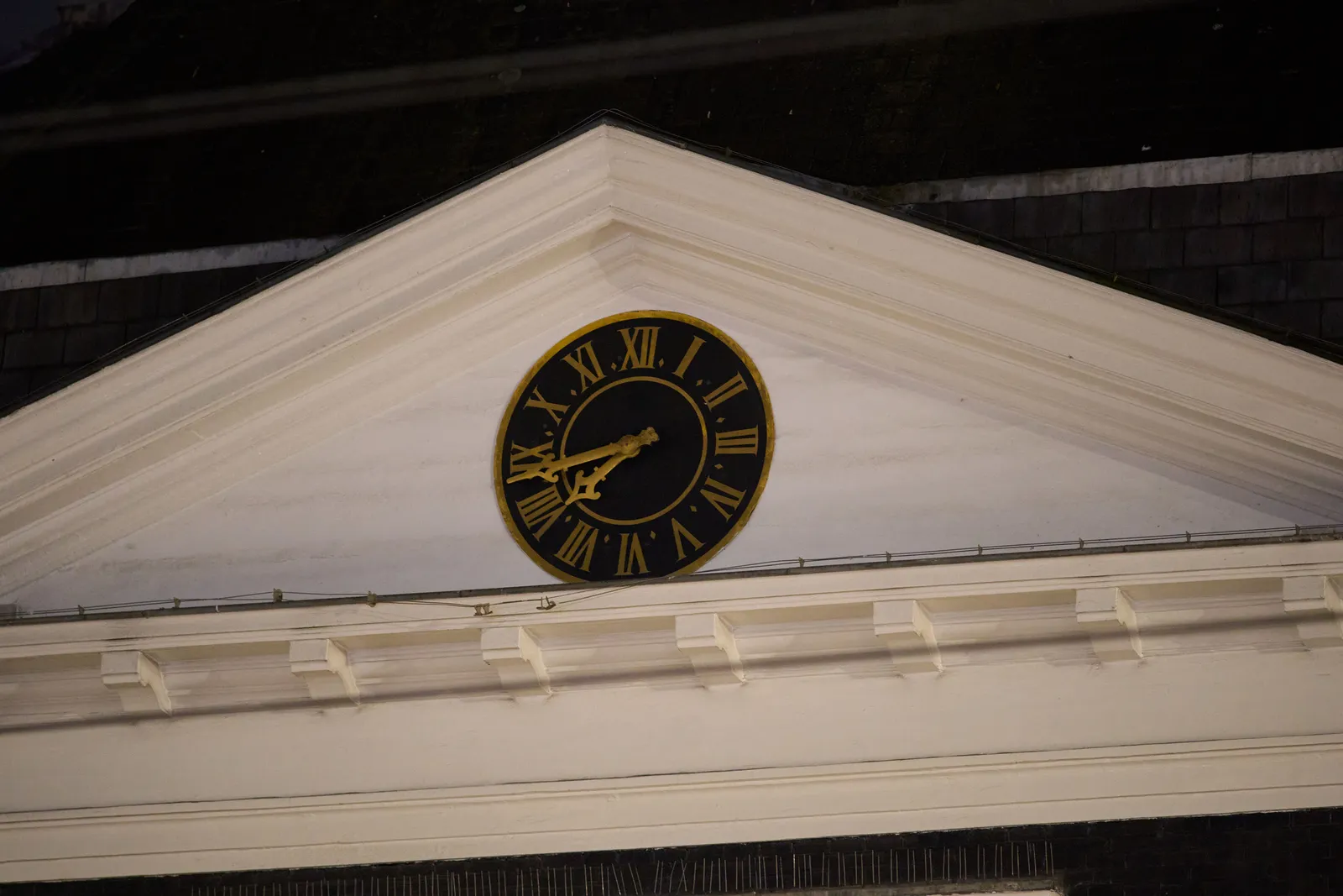 A clock in a triangular tympanum. It points at 17 minutes to 8.