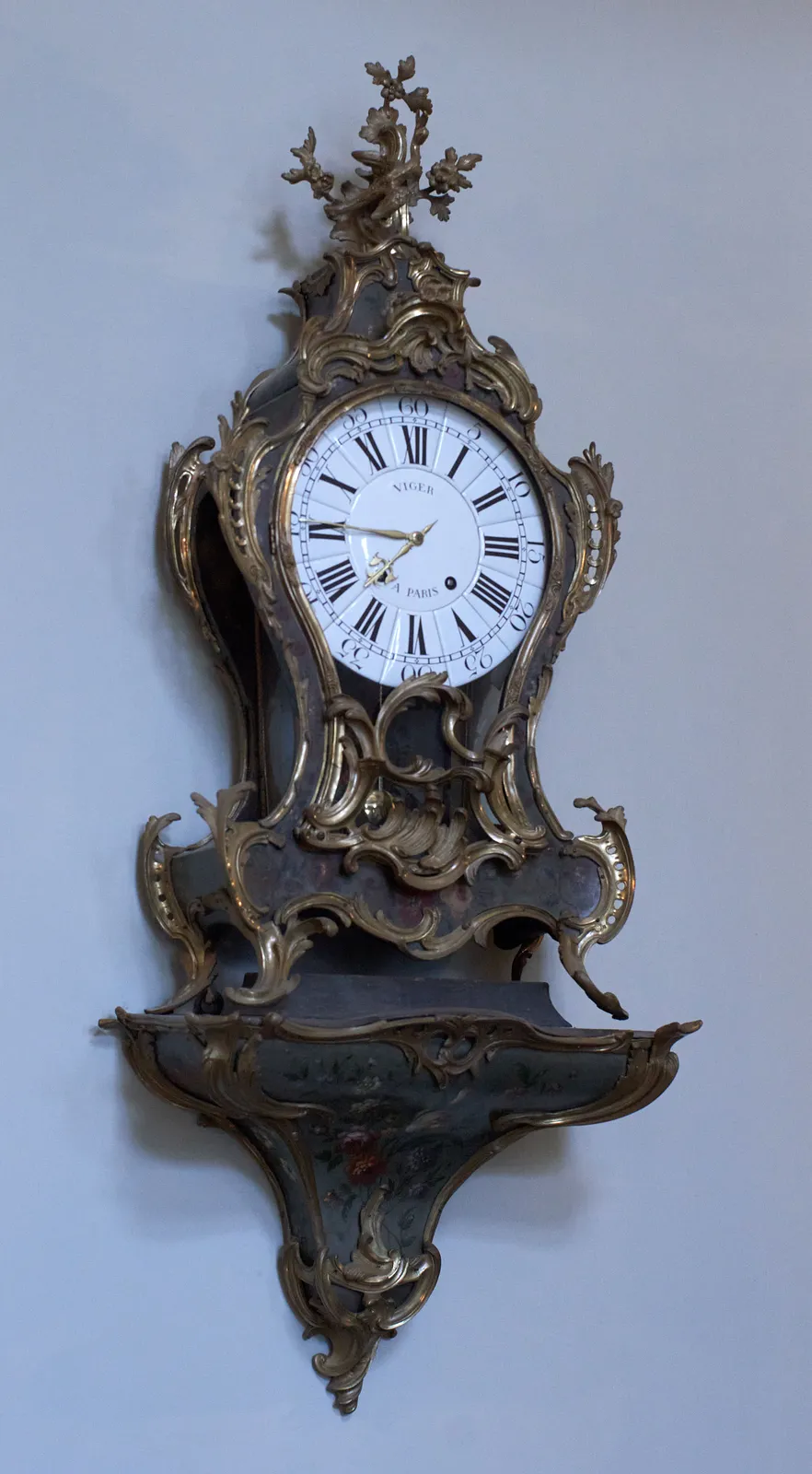 A richly ornamented golden clock, with a face made from porcelain tiles. On this clock it is a quarter to eight.
