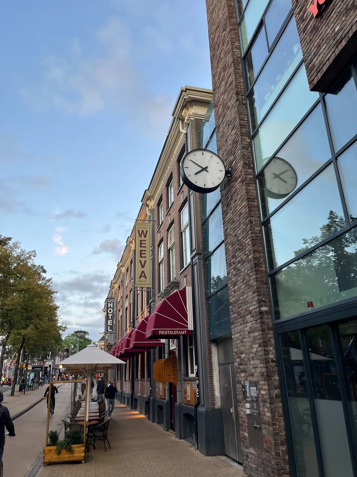 A clock attached to a building. It points at 10 to 8.