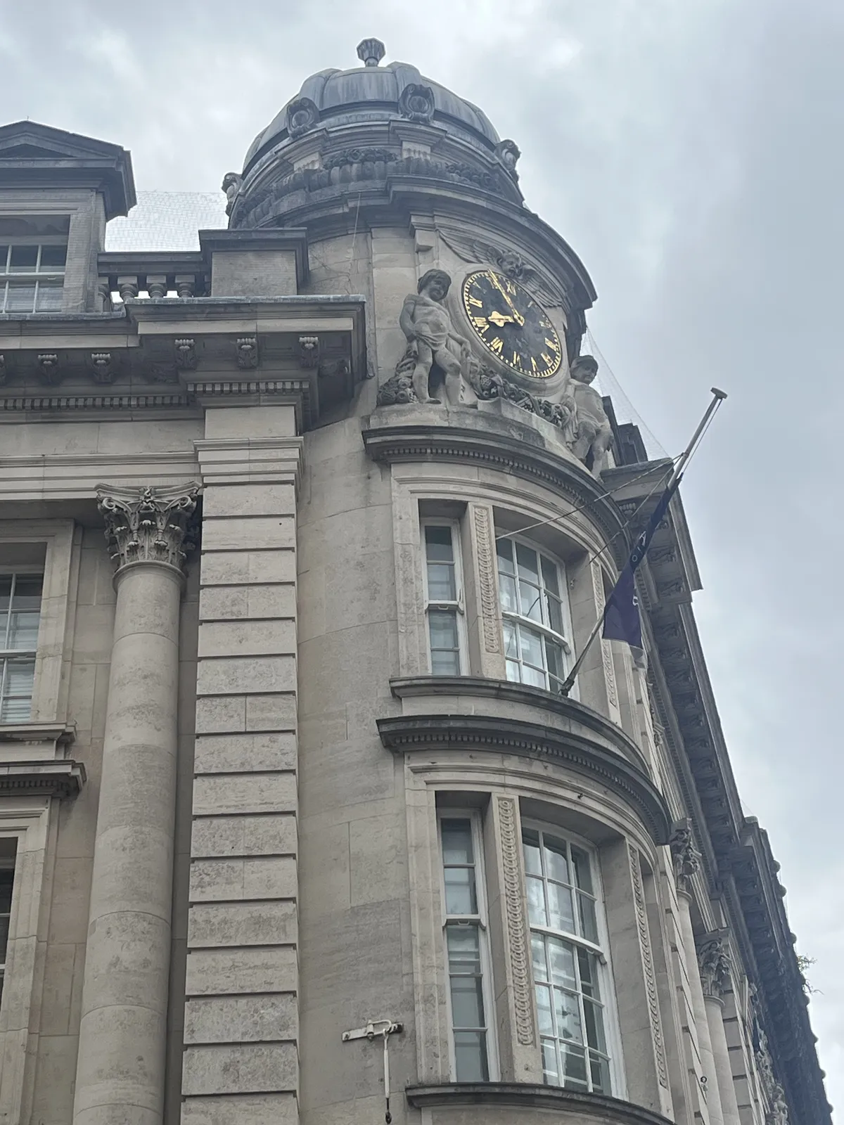 A clock on a richly ornamented facade. Korinthian columns, cherubs looking down at us. Between the cherubs there’s a clock which points at 5 minutes to eight.