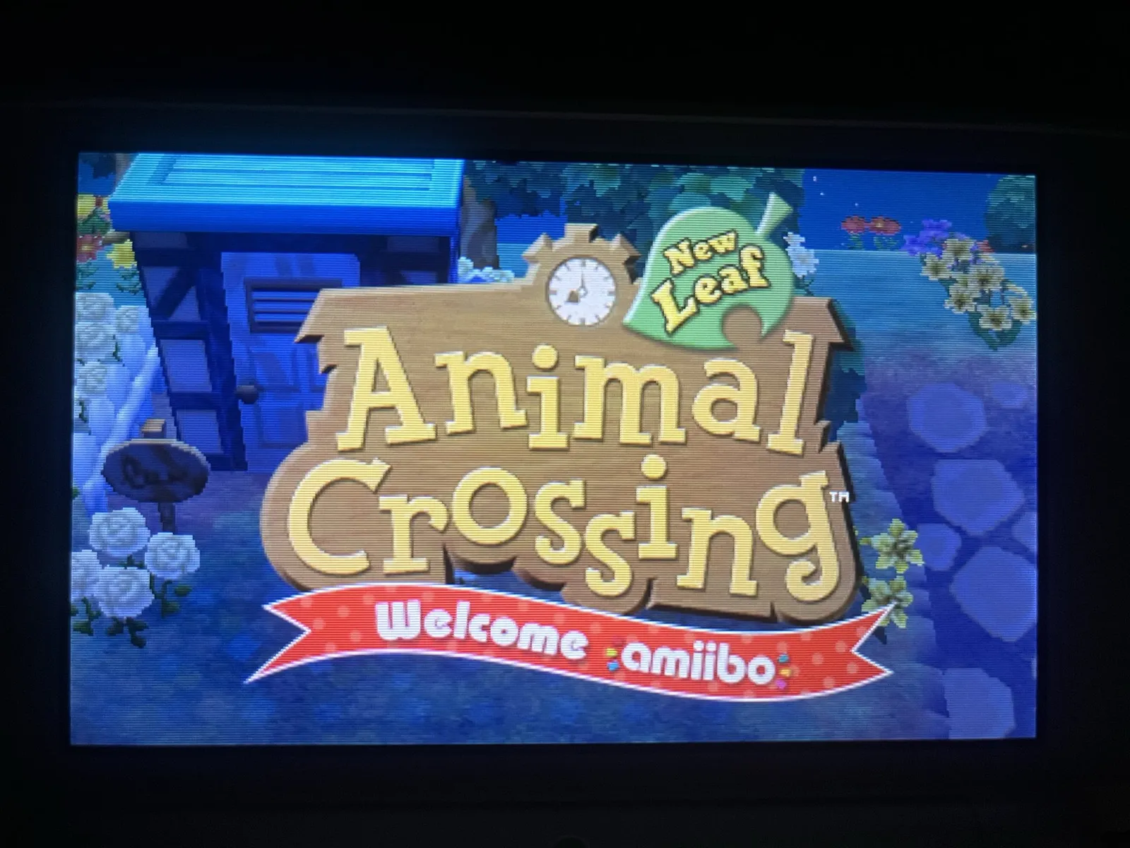 A pixelated screenshot from the game Animal Crossing New Leaf. There’s a clock in the logo, which points at eight o’clock.