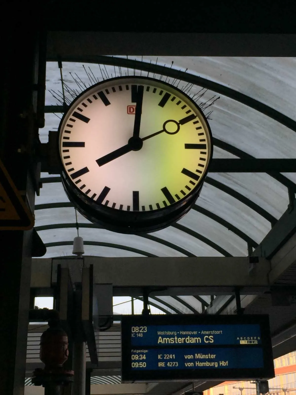 A clock on a station in Germany, on the platform where the train to Amsterdam will be leaving, shows it is one minute past eight. 