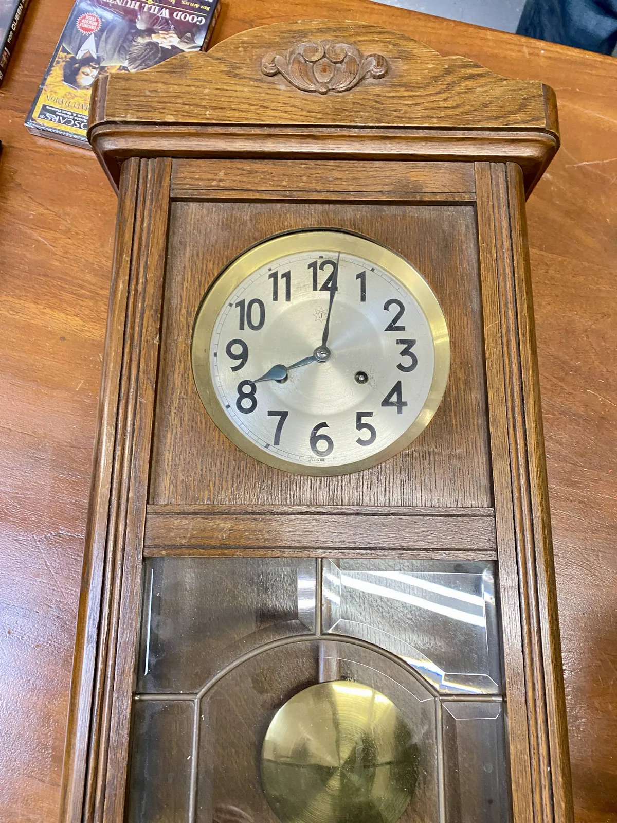 A wooden clock. It points at 1 past 8.