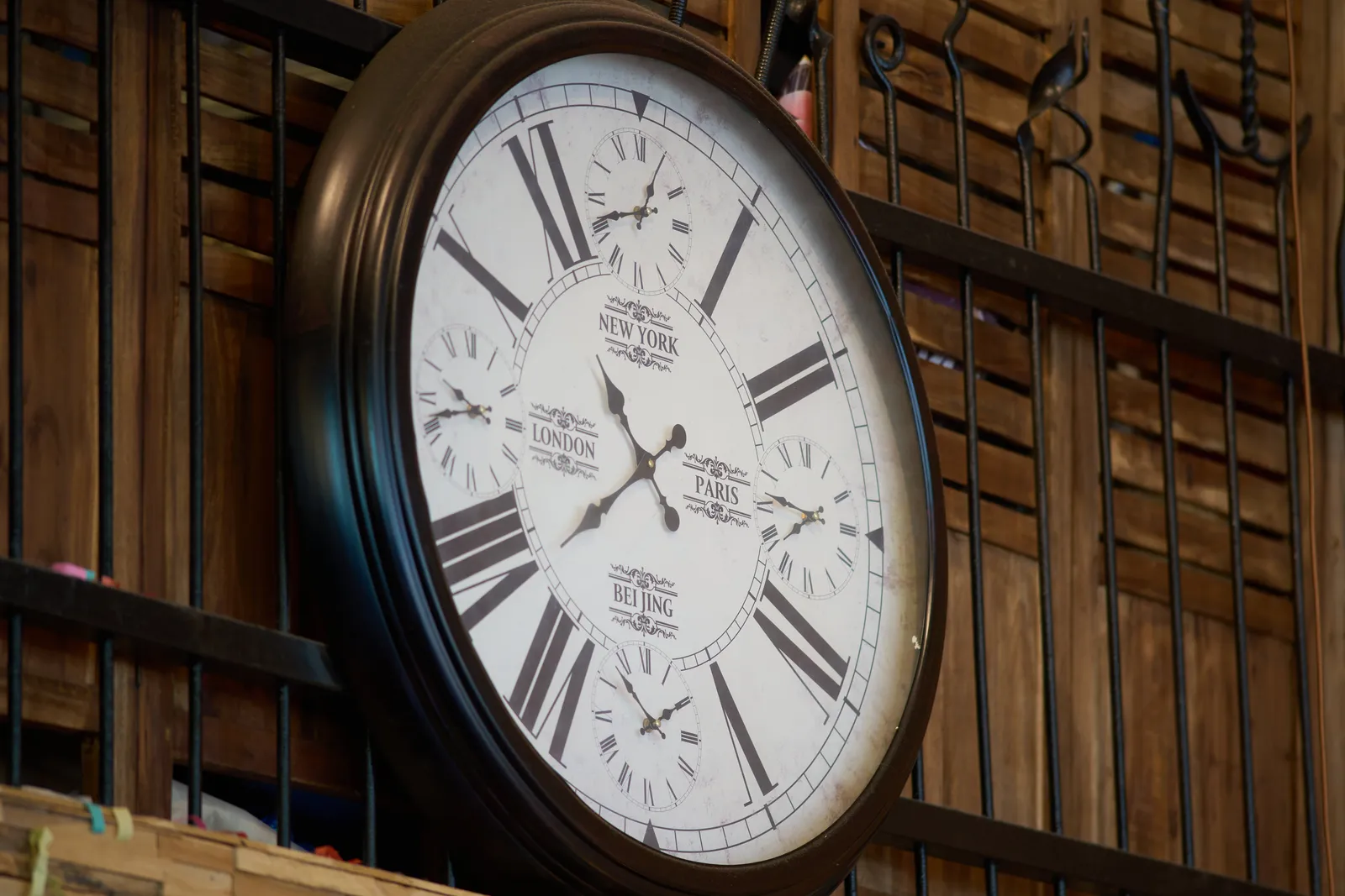 A large clock, with four small clocks on its face. The all point at different times, supposedly in different cities in the world. The main clock points at 38 minutes past 10. The four small clocks point at 7 minutes to 2, 14 minutes to 8, five past 8, and 18 minutes to 10.