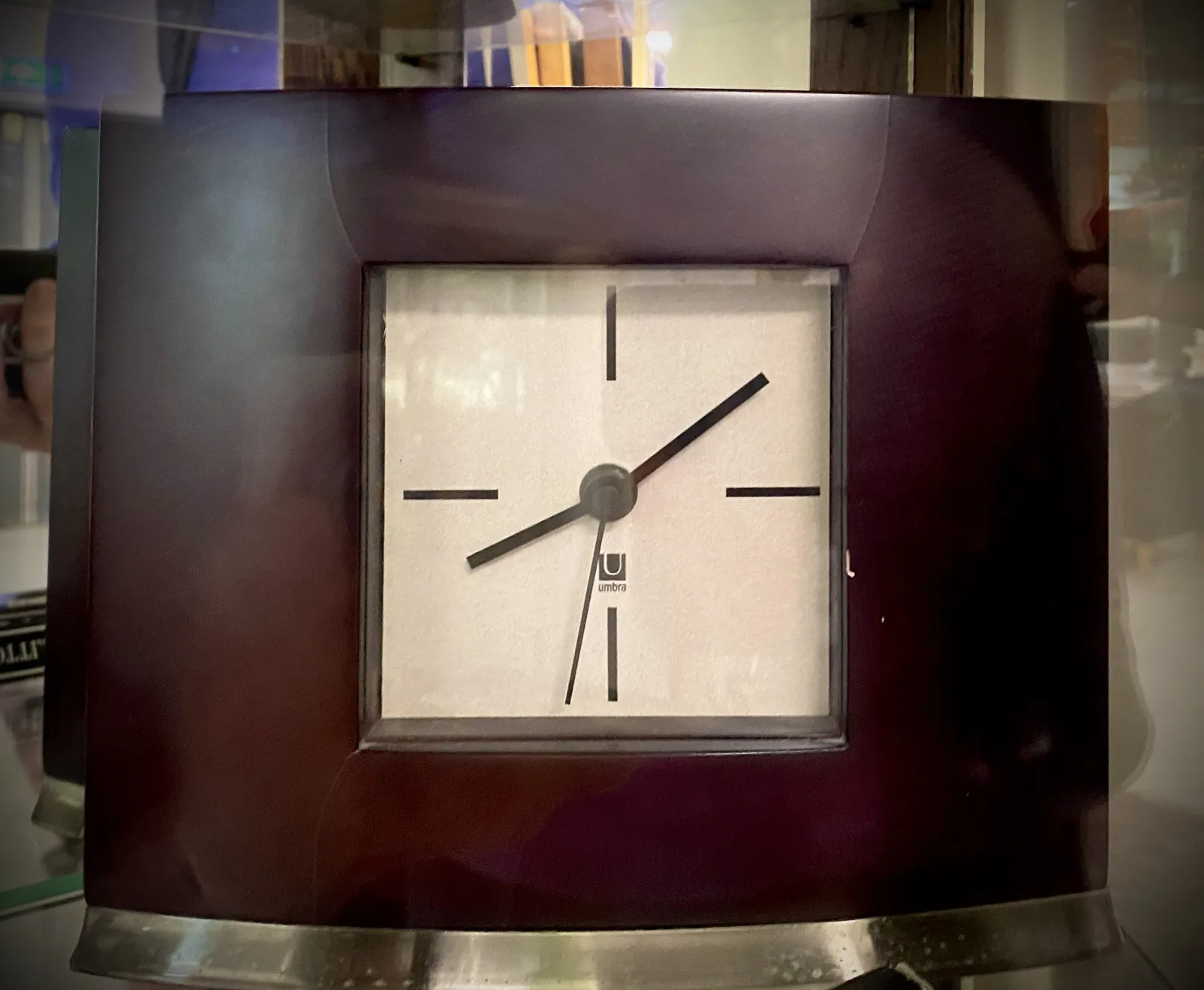 A small clock, the size is not exactly clear. It could be a small table clock, it could also be a bit bigger, like a mantel clock. It points at 8 minutes past 8.