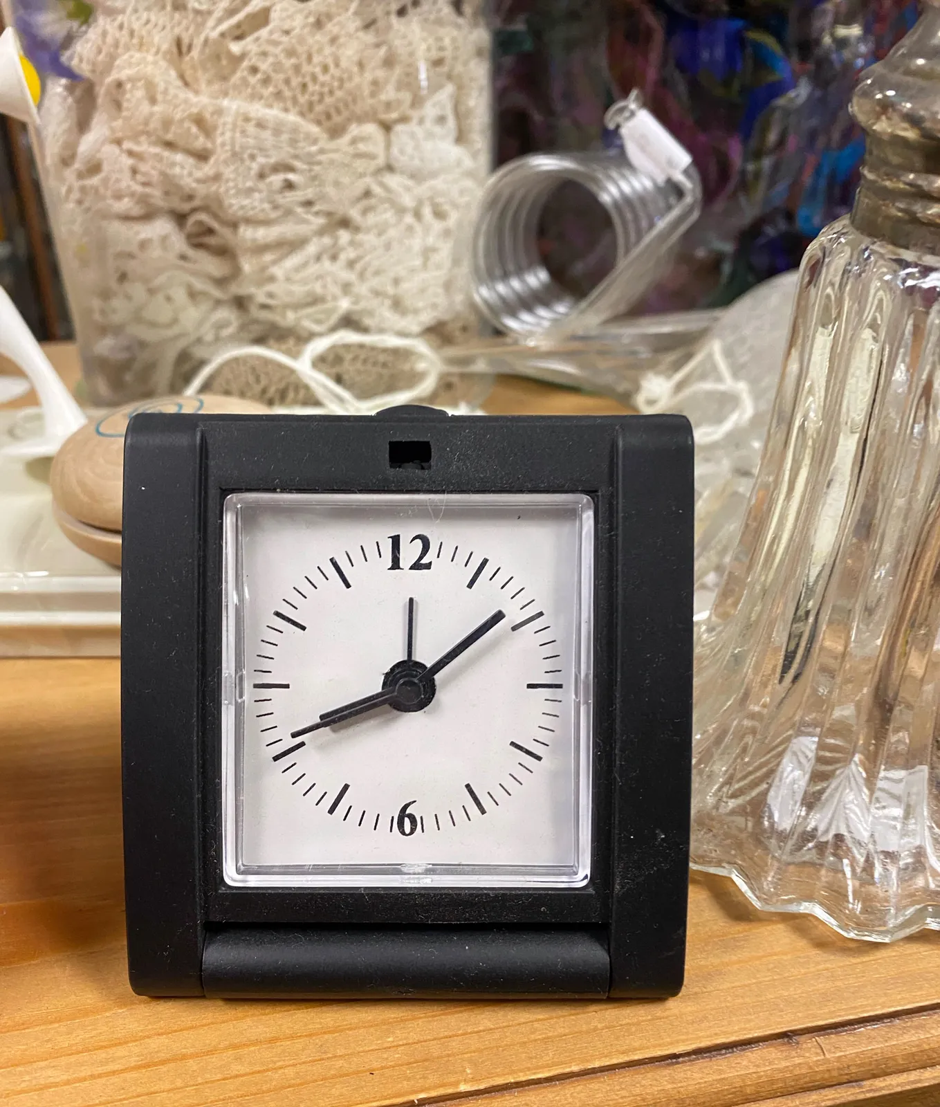 A small table clock. It points at 8 minutes past 8.