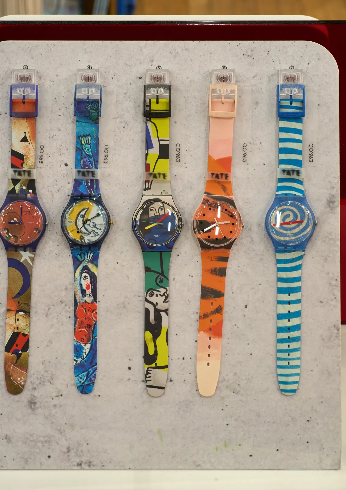 Five arty swatch watches on display. One of them points at 36 past two. Another points at 16 minutes to three, and then there’s one that seems to points at approximately ten past seven. There’s one that points at approximately 8 minutes past eight, and the last one points at nine o’clock.