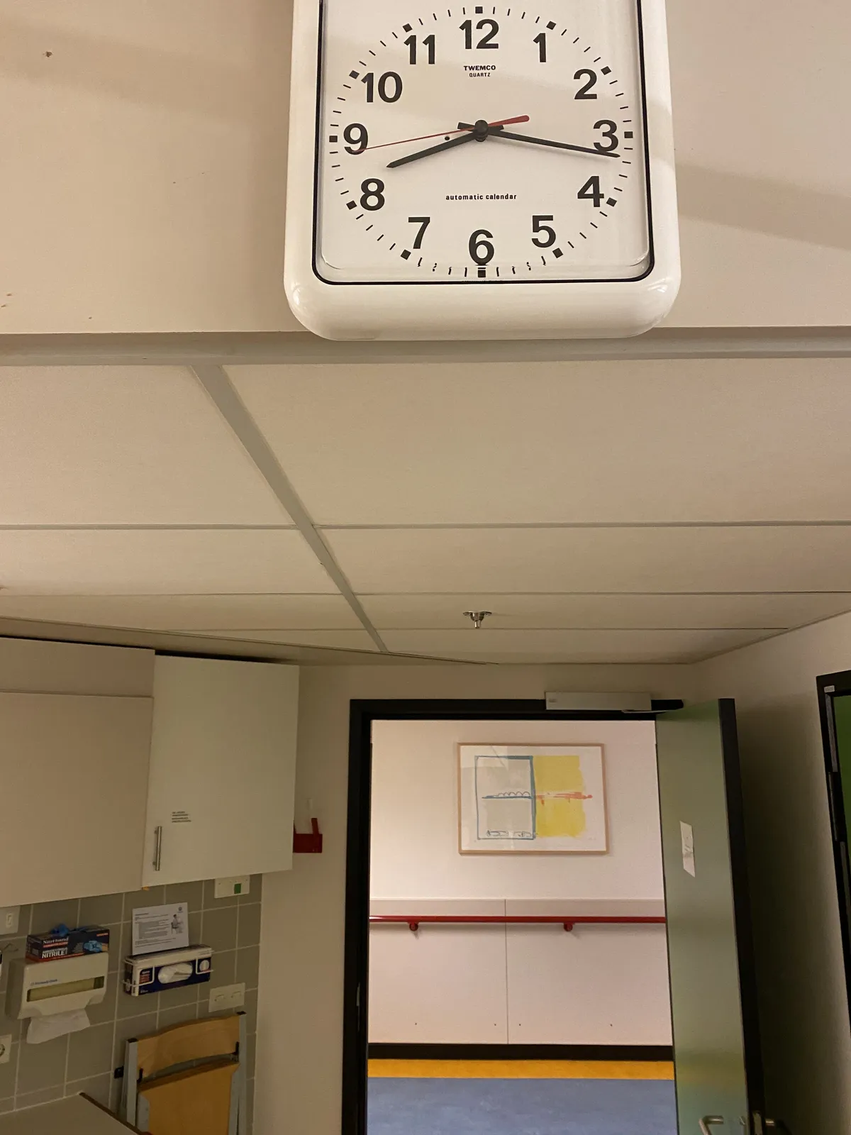 A clock above a door. It points at 17 past 8.