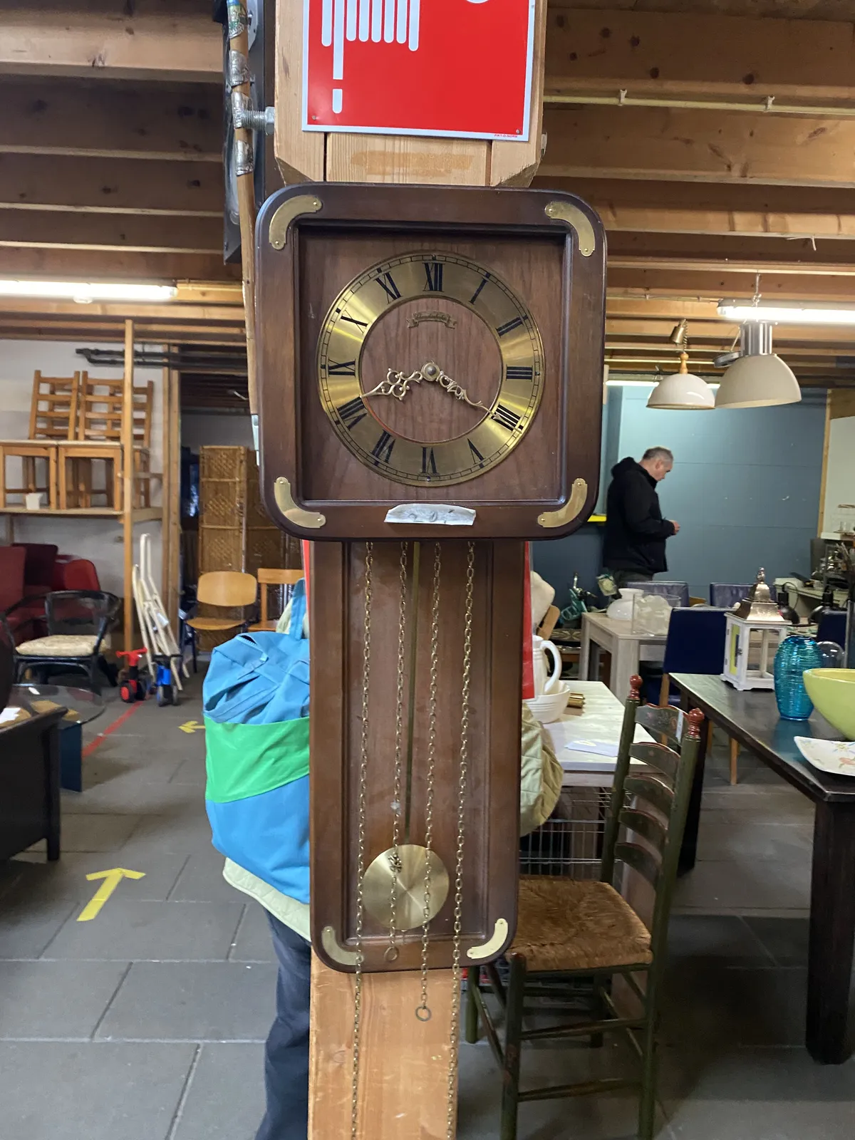 A wooden clock in a thrift shop points at 20 past 8.